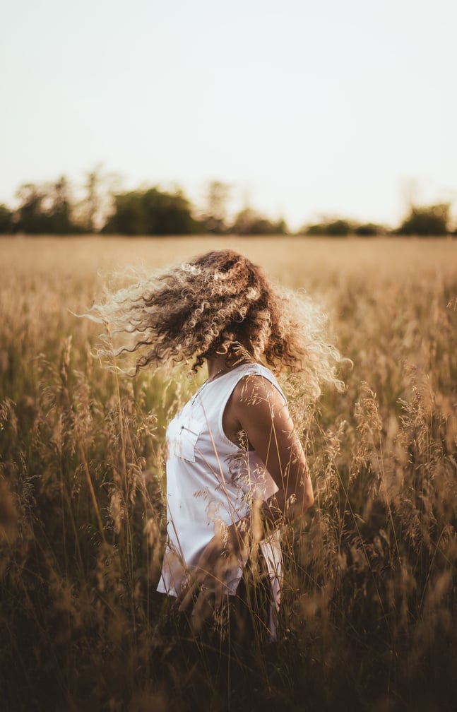 Faceless woman standing in grassy field